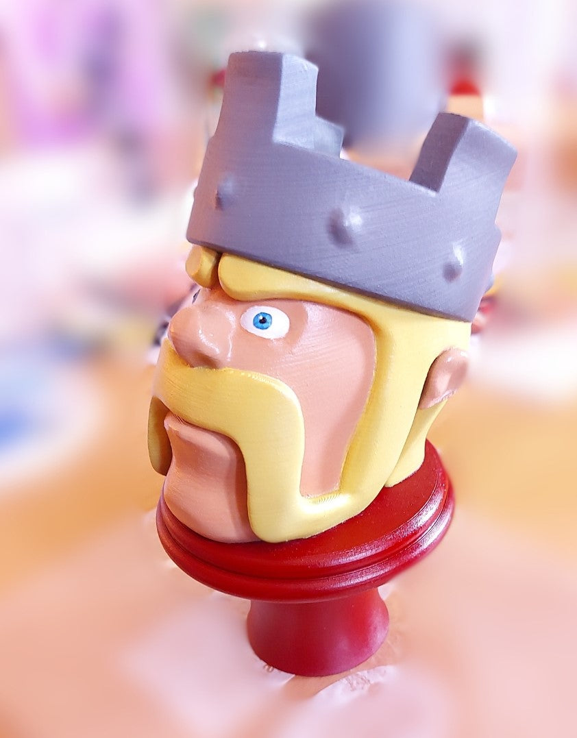 Toy figure of a character with a crown and red base on a blurred background