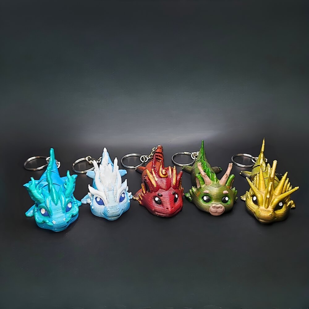 Close-up of five colorful Elemental Dragon keychains, 3D printed and hand-painted. Full of personality, grouped together in a display. Family Bundle 5 dragons for the price of 4. 