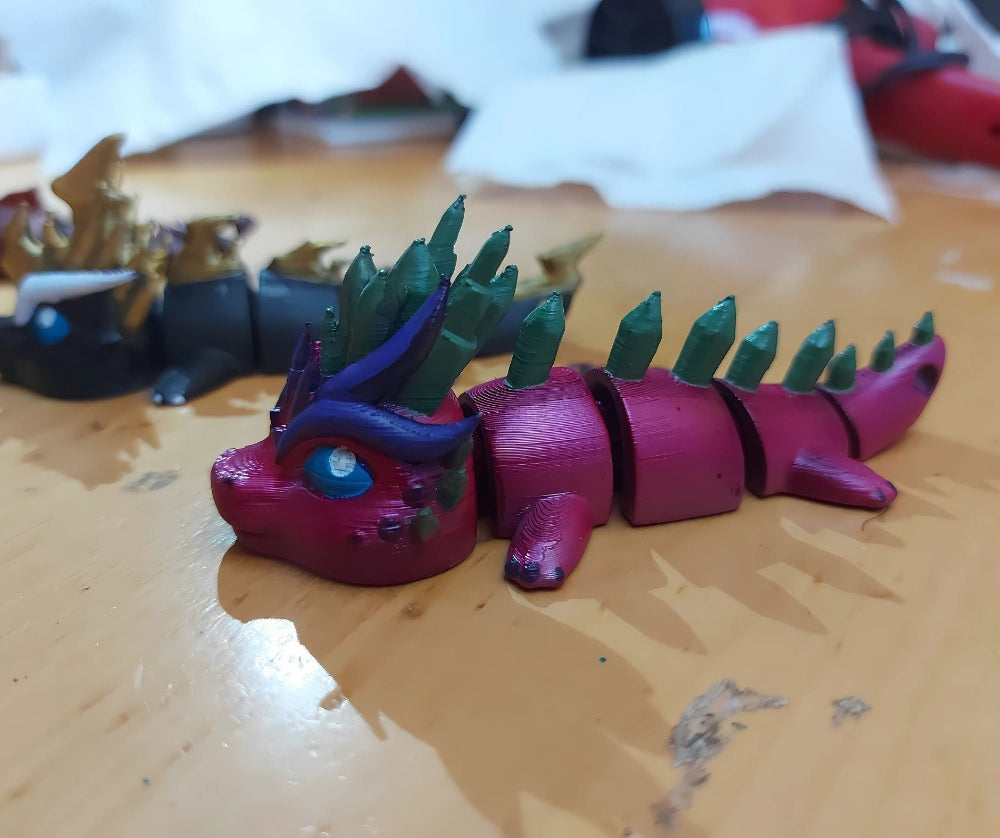 Customer photo featuring custom hand-painted dragons by Kylyne’s Custom Treasures, displayed on a colorful table for review or testimonial use