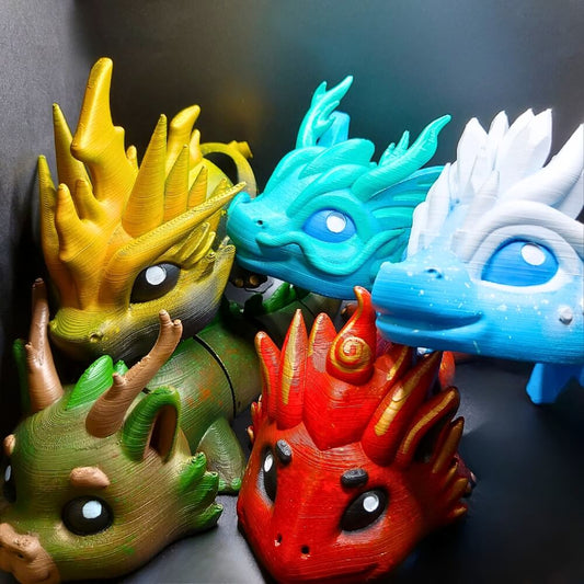 Close-up of five colorful Elemental Dragon faces, hand-painted and full of personality, grouped together in a display.