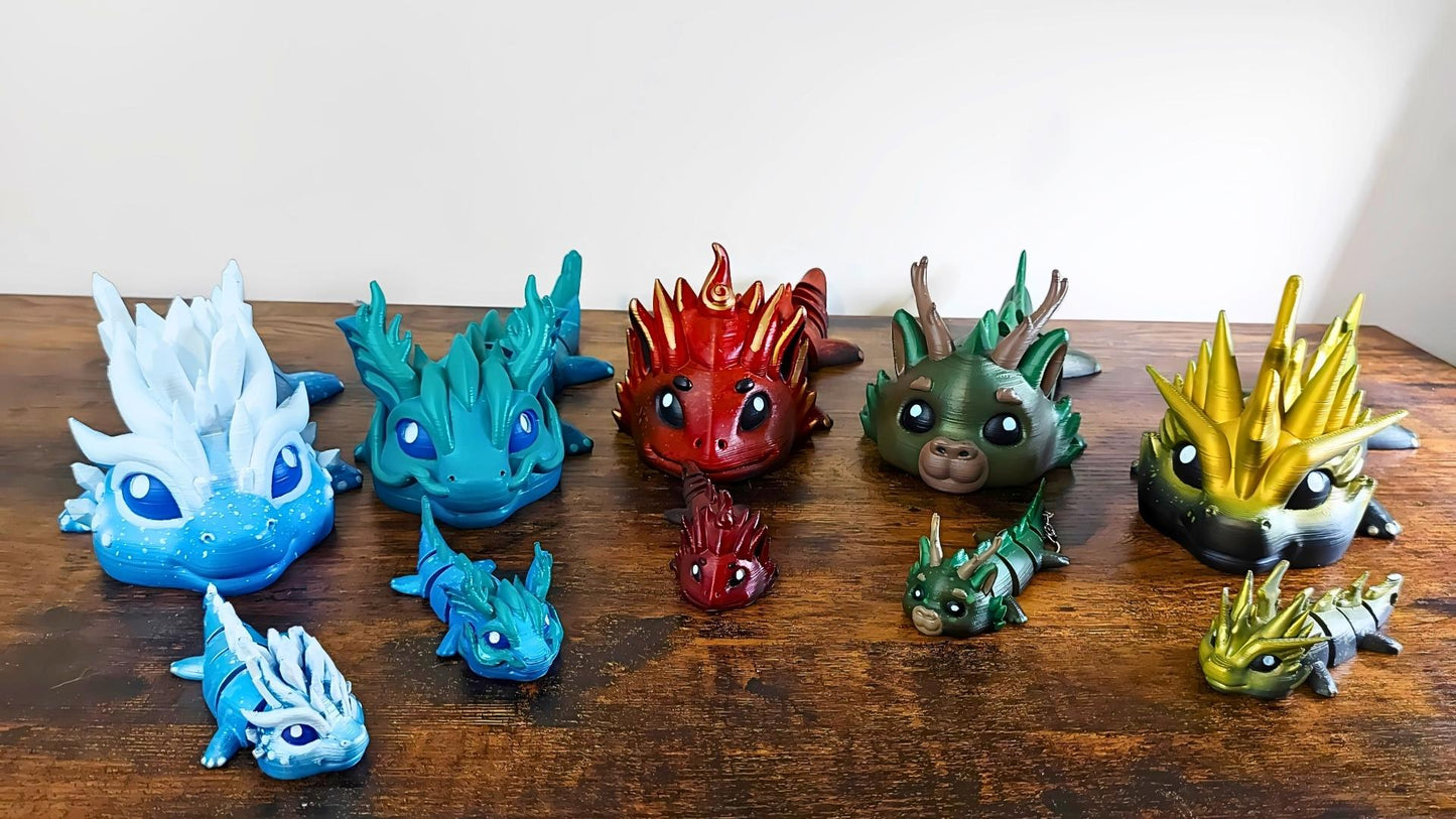 Group of five hand-painted Elemental Dragon keychains by Kylyne’s Custom Treasures, displayed on a clean desk with natural lighting