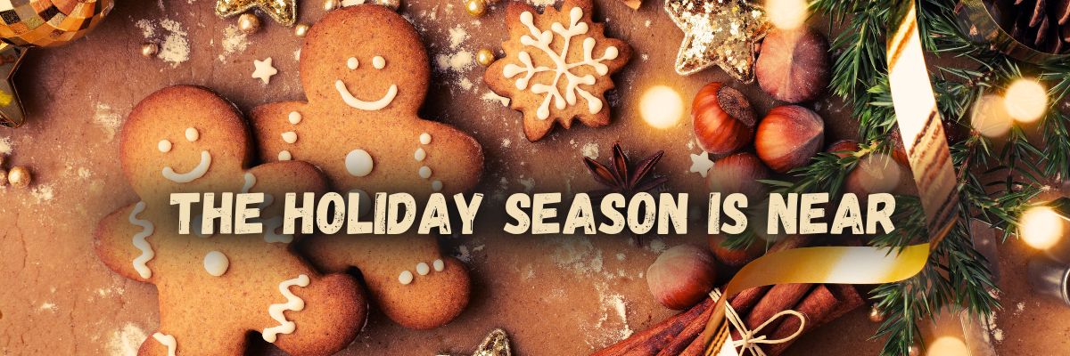 Holiday season banner with smiling gingerbread cookies, festive ribbon, fir branches, cinnamon sticks, hazelnuts, and gold decorations, featuring the text ‘The Holiday Season is Near’.
