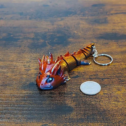Keychain size Kaelix the Fire Elemental Dragon of Drakora, 3D-printed and hand-painted by Kylyne’s Custom Treasures, displayed on a wood background with a coin for scale.