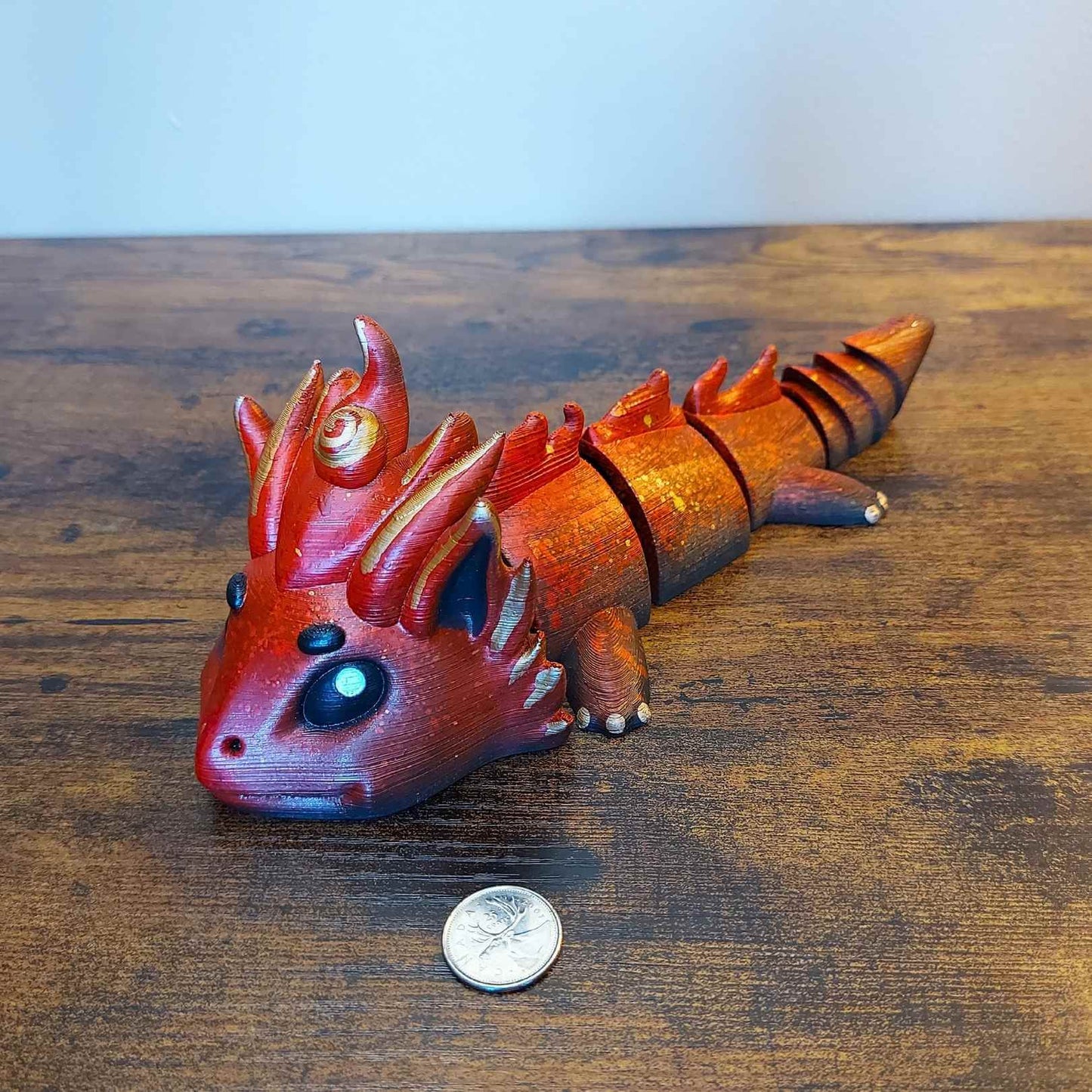 Large Kaelix the Fire Elemental Dragon of Drakora, 3D-printed and hand-painted by Kylyne’s Custom Treasures, displayed on a wood background with a coin for scale.