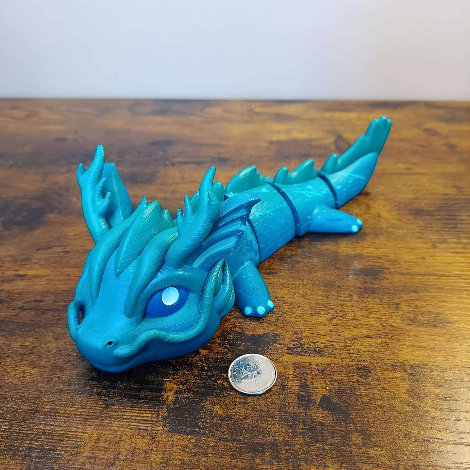 Large Vaylen the Sea Elemental Dragon of Drakora, 3D-printed and hand-painted by Kylyne’s Custom Treasures, displayed on a wood background with a coin for scale.