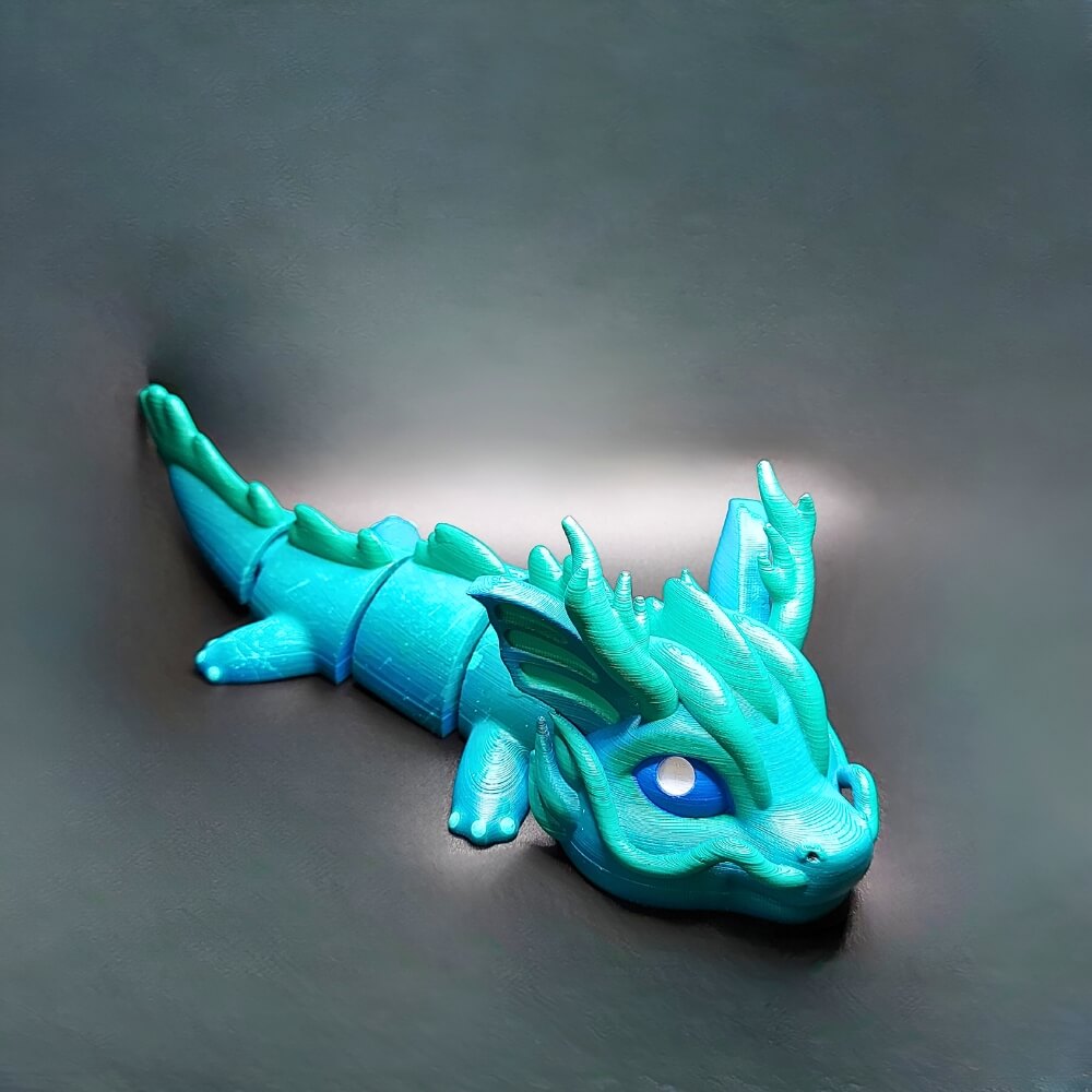 Handcrafted Sea Dragon Vaylen collectible keychain in blue and turquoise, front view showing wave patterns