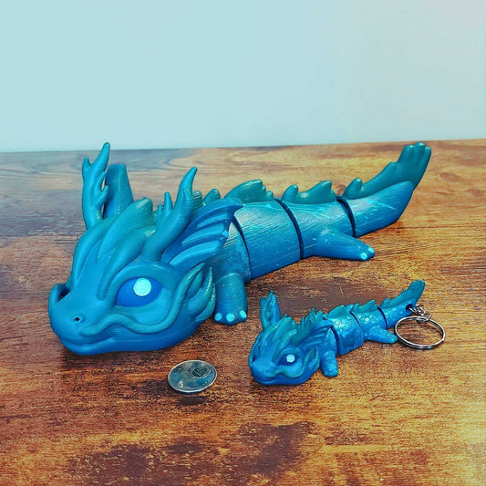 Large and keychain size Vaylen the Sea Elemental Dragon of Drakora, 3D-printed and hand-painted by Kylyne’s Custom Treasures, displayed on a wood background with a coin for scale.