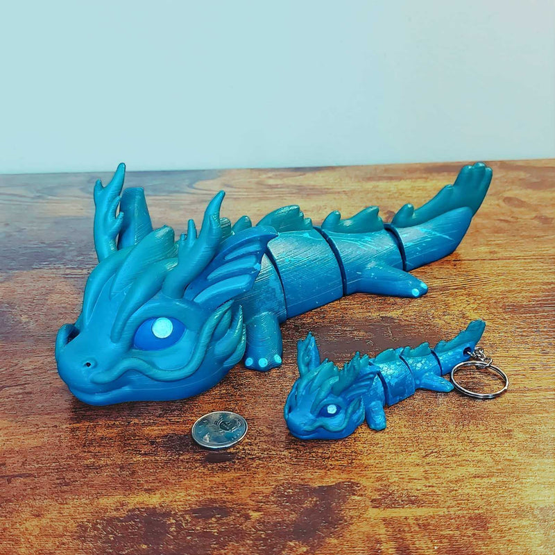 Large and keychain size Vaylen the Sea Elemental Dragon of Drakora, 3D-printed and hand-painted by Kylyne’s Custom Treasures, displayed on a wood background with a coin for scale.