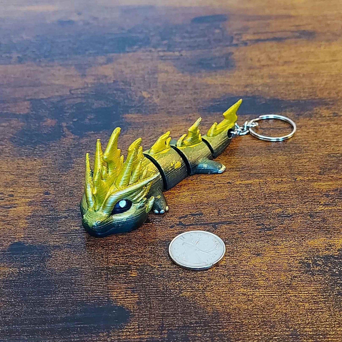 Keychain size Zoryn the Thunder Elemental Dragon of Drakora, 3D-printed and hand-painted by Kylyne’s Custom Treasures, displayed on a wood background with a coin for scale.