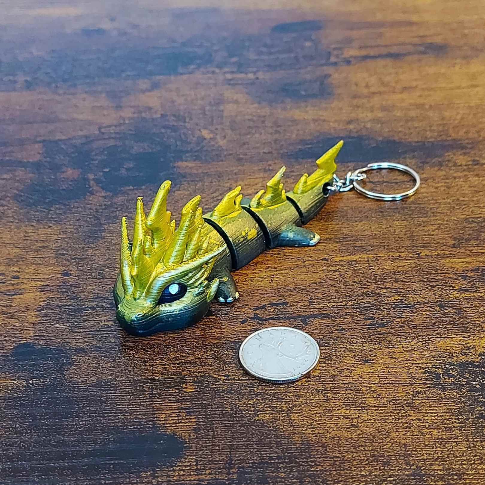 Keychain size Zoryn the Thunder Elemental Dragon of Drakora, 3D-printed and hand-painted by Kylyne’s Custom Treasures, displayed on a wood background with a coin for scale.