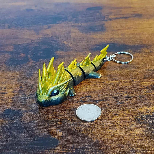 Keychain size Zoryn the Thunder Elemental Dragon of Drakora, 3D-printed and hand-painted by Kylyne’s Custom Treasures, displayed on a wood background with a coin for scale.