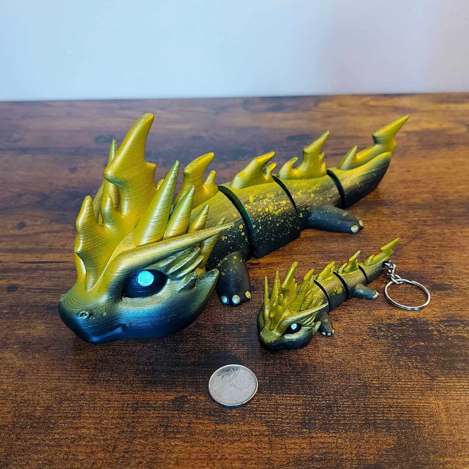 Large and keychain size Zoryn the Thunder Elemental Dragon of Drakora, 3D-printed and hand-painted by Kylyne’s Custom Treasures, displayed on a wood background with a coin for scale.
